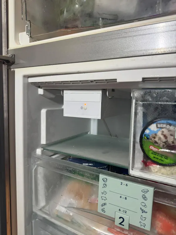 Ice maker module with an indicator light and on/off button inside a built-in bottom freezer