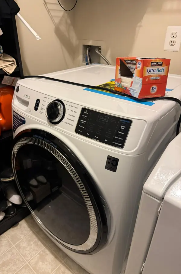 GE front-load washer with the UltraFresh Vent System door in a laundry room
