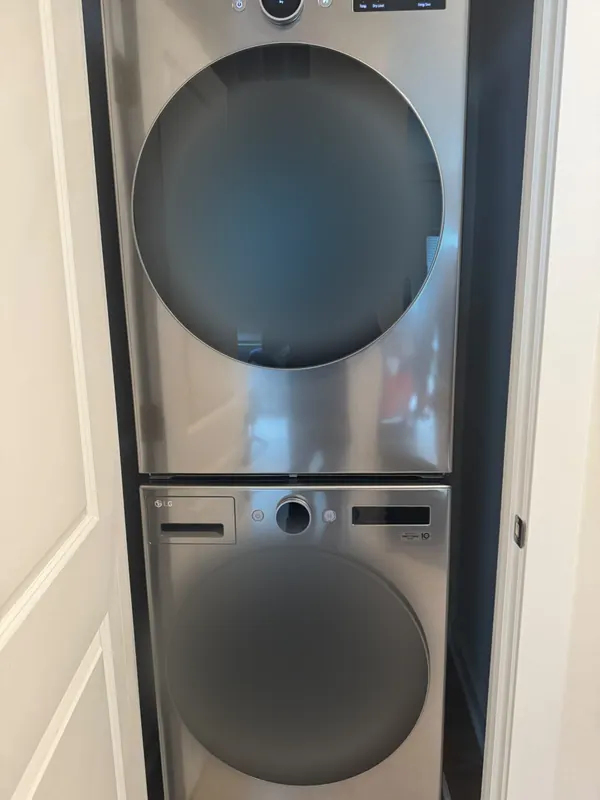 LG washer and dryer in a stainless finish stacked in a laundry closet
