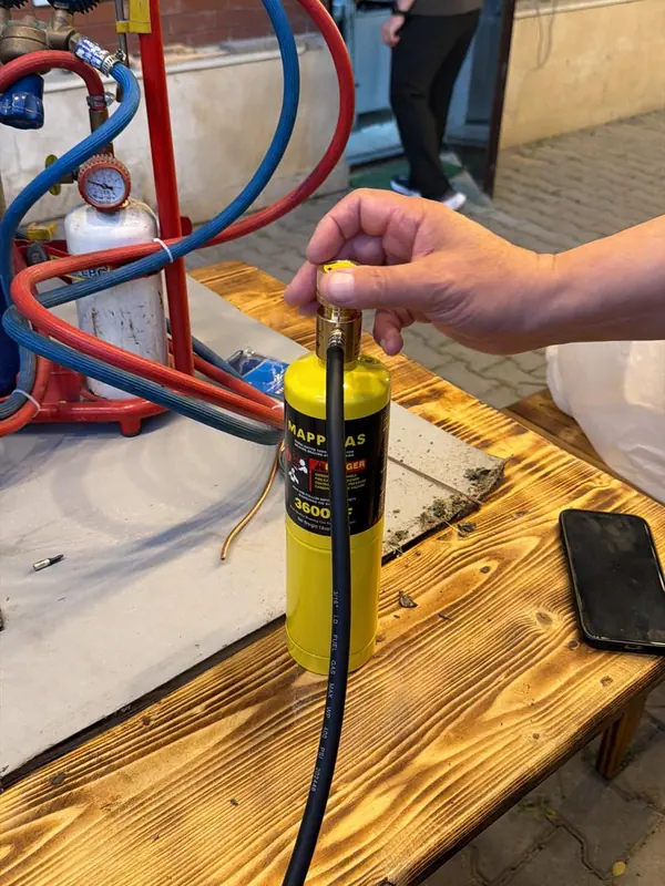 MAPP gas cylinder and torch hose next to an oxygen and fuel cart with gauges on a workbench