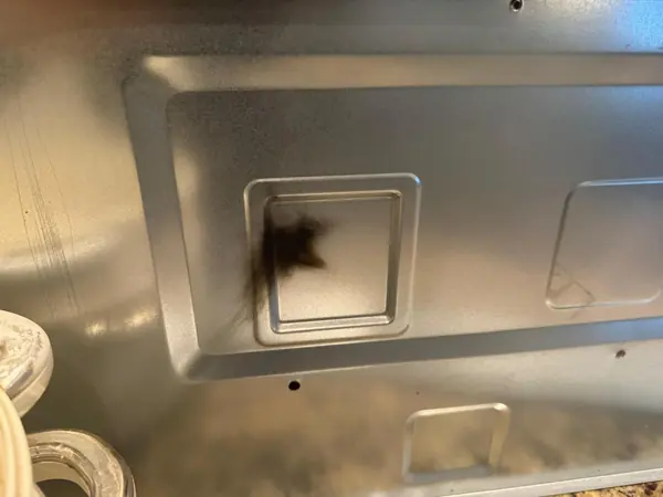 Burn mark from arcing on a microwave cavity wall next to the waveguide cover