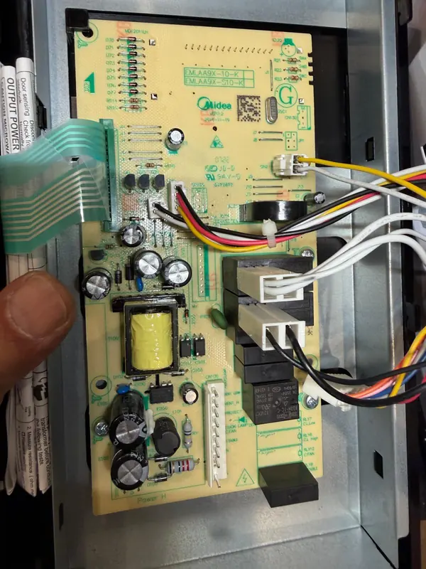Microwave control board with relays, power supply and the keypad ribbon cable exposed during diagnosis