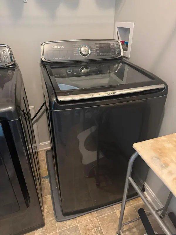 Samsung activewash top-load washer with a glass lid in a laundry room