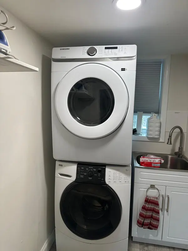 Samsung front-load dryer stacked on a Kenmore Elite front-load washer in a laundry room