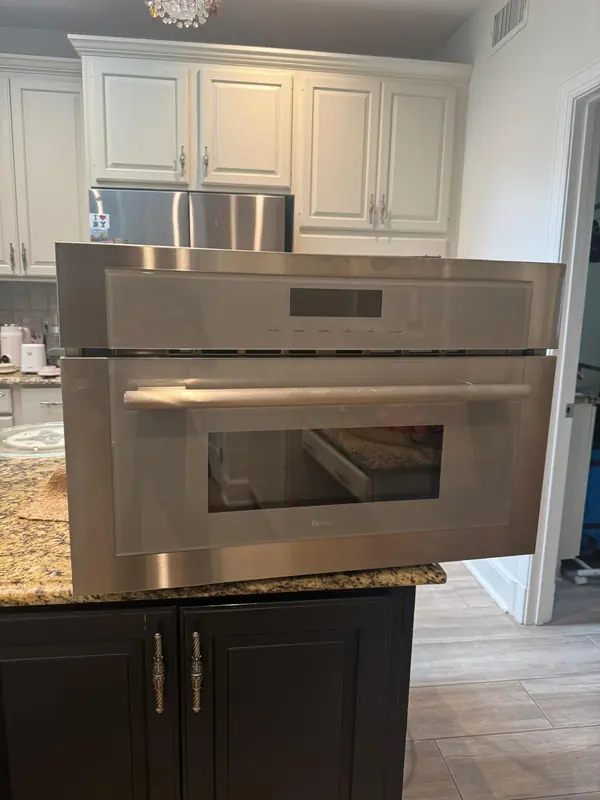 Thermador built-in microwave removed from its cabinet and set on a kitchen island